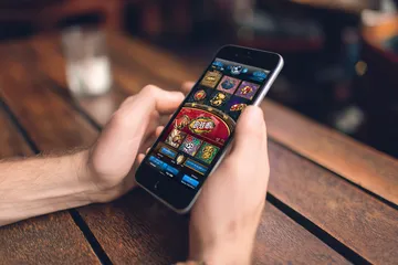 উৎসবের মুহূর্তে ঐতিহ্যবাহী পোশাক পরা এক আনন্দিত নারী তার স্মার্টফোন ব্যবহার করছেন, যা দেখায় 456BDBET অ্যাপ কীভাবে দৈনন্দিন জীবনের সঙ্গে সহজে মানিয়ে যায়।